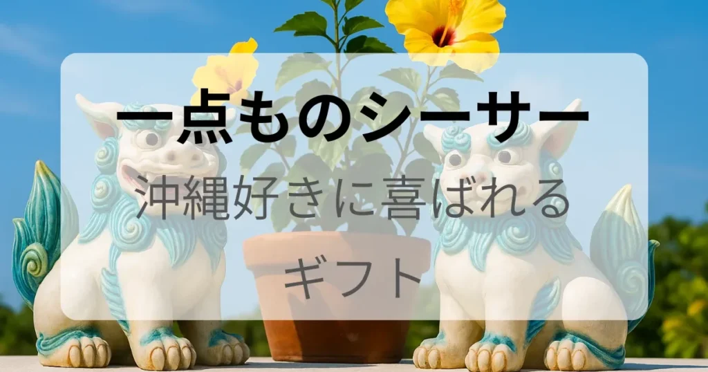 白とターコイズカラーのシーサーが2体並び、黄色いハイビスカスと「沖縄好きに喜ばれる一点ものギフト」を伝えるテキストが重なっている画像。